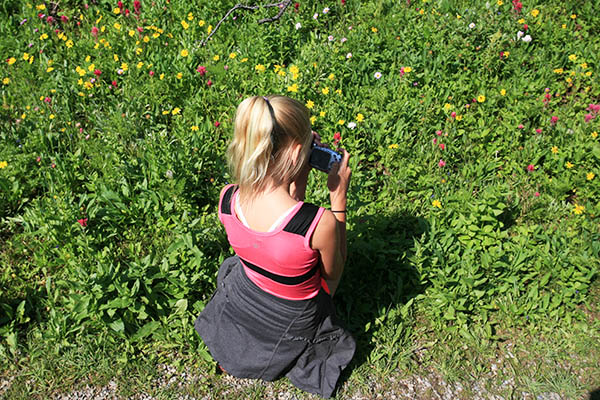 A young visitor to the Canadian Rockies stops to photograph trailside wildflowers.